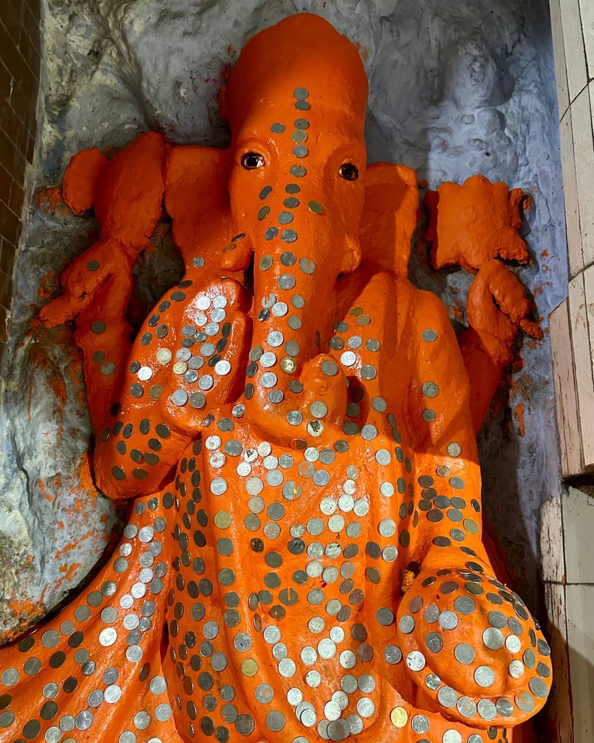 Ganesha statue covered in coin offerings