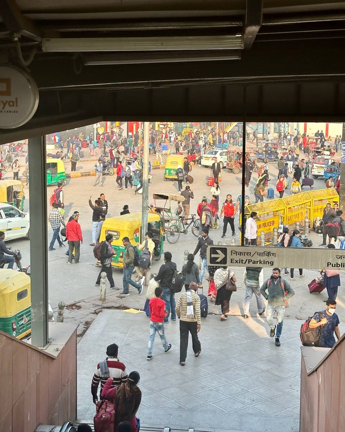 New Delhi Railway Station entrance with crowds and auto-rickshaws