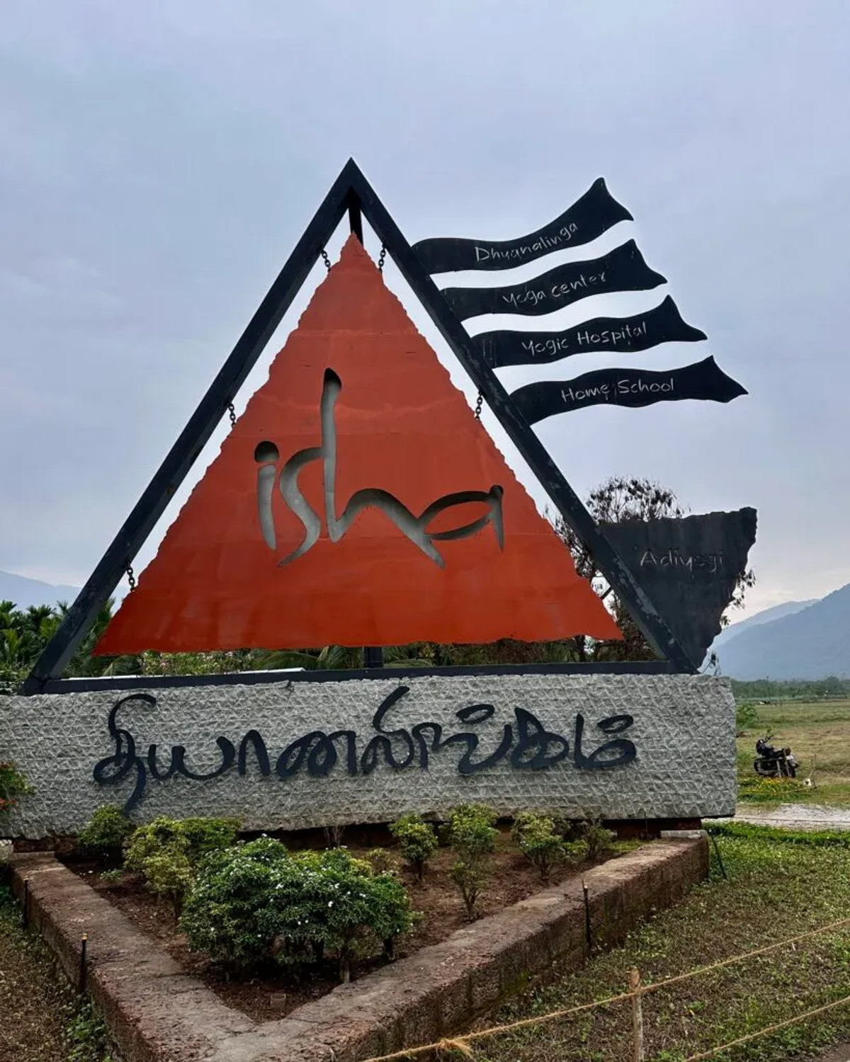Isha Yoga Center entrance sign with triangle logo and flags