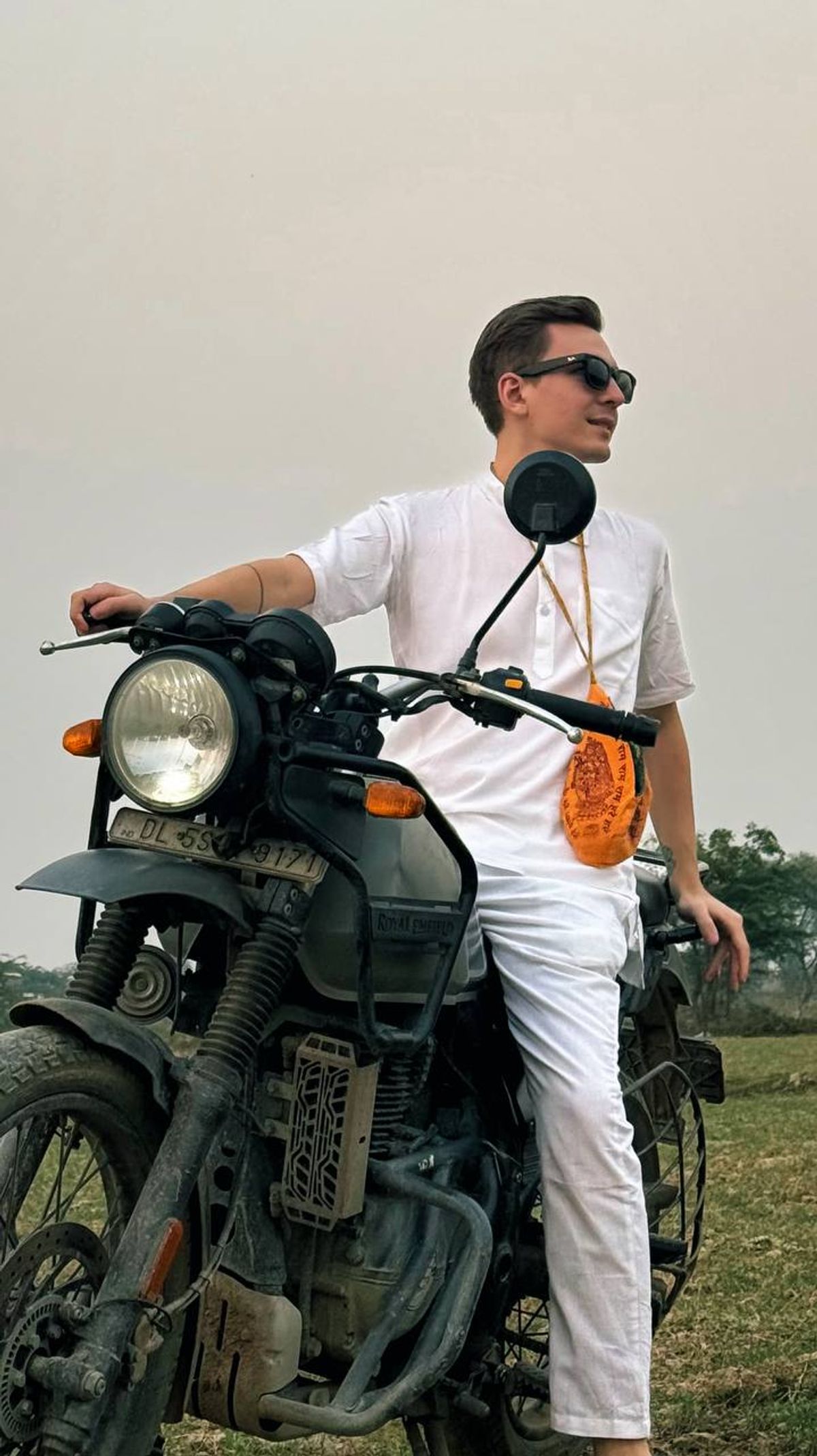 Alex Pervov on a Royal Enfield motorcycle in the Braj countryside