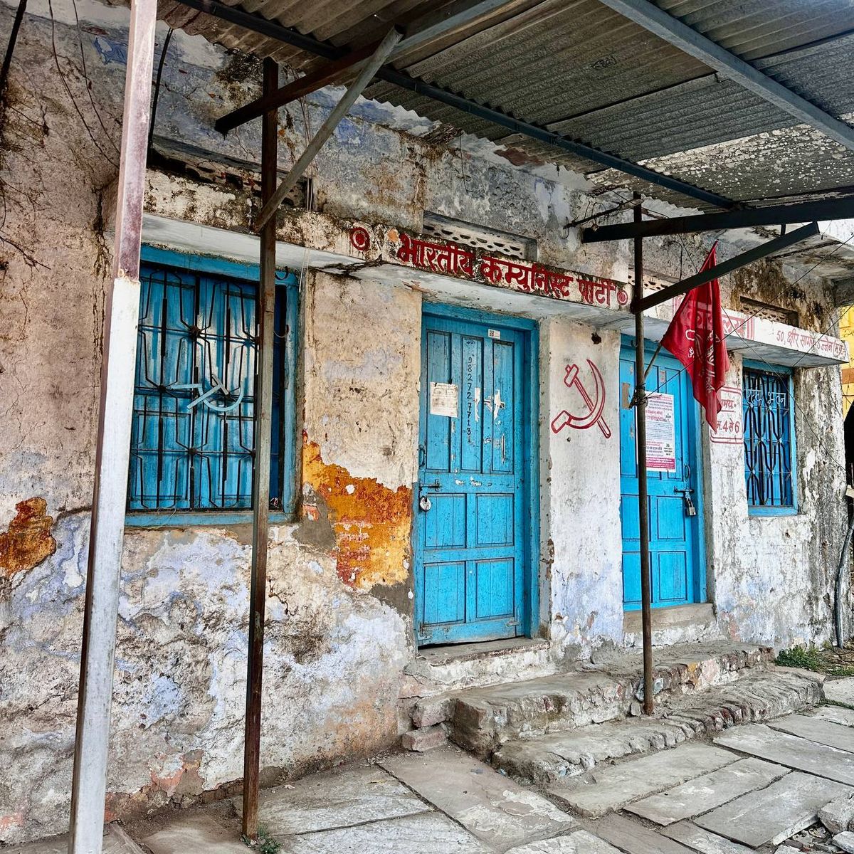 Communist party office with blue doors and hammer and sickle