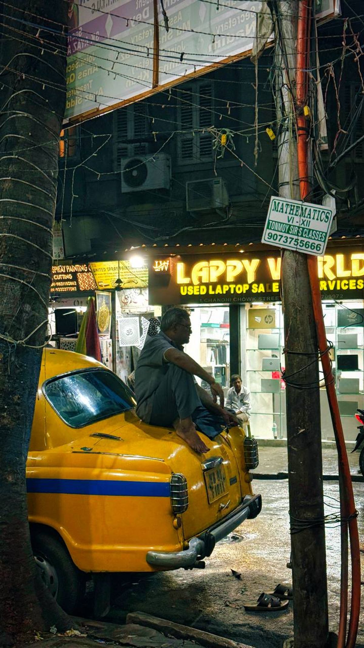 Taxi driver sitting on his Ambassador in a busy Kolkata lane