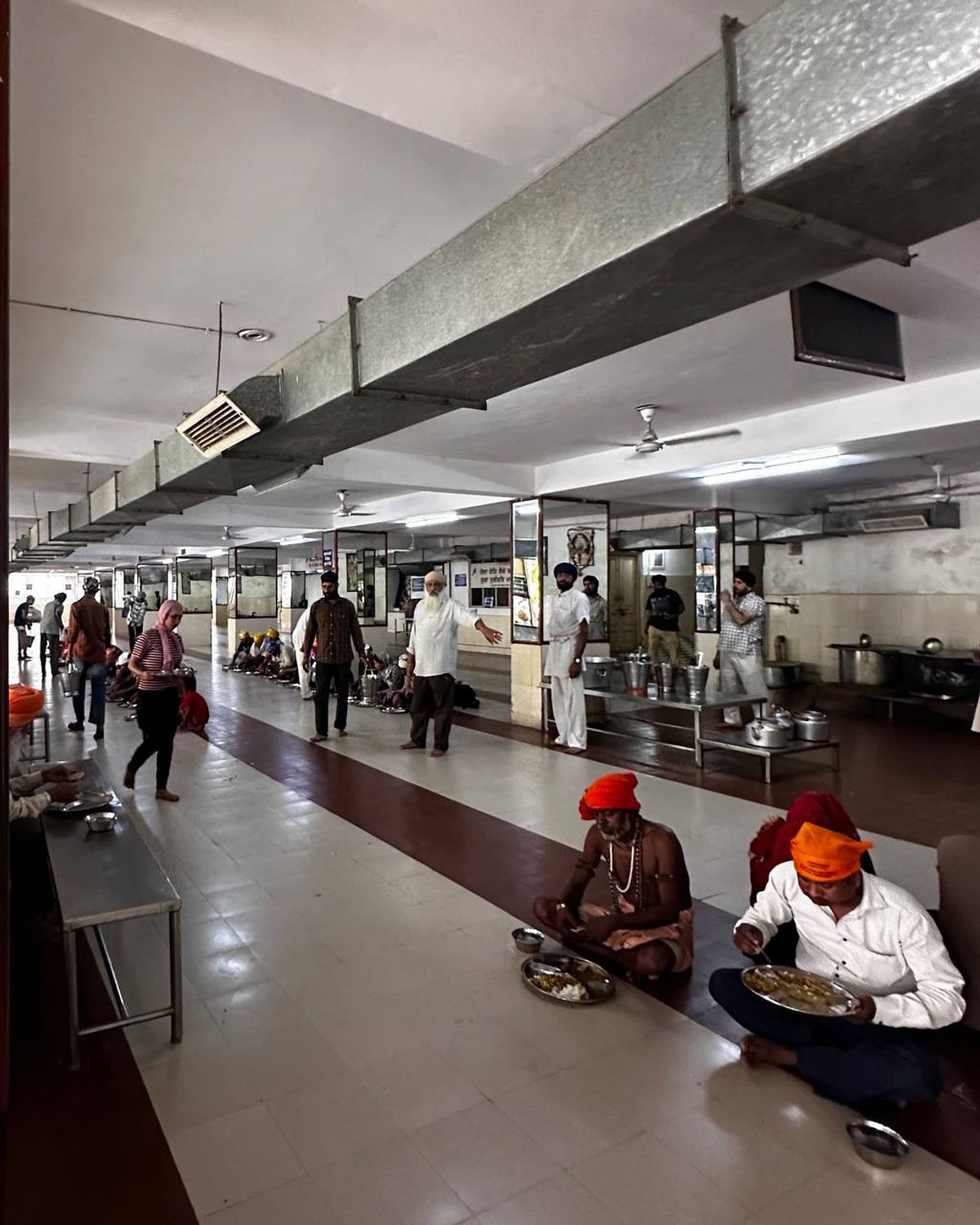 Langar hall with people eating on floor