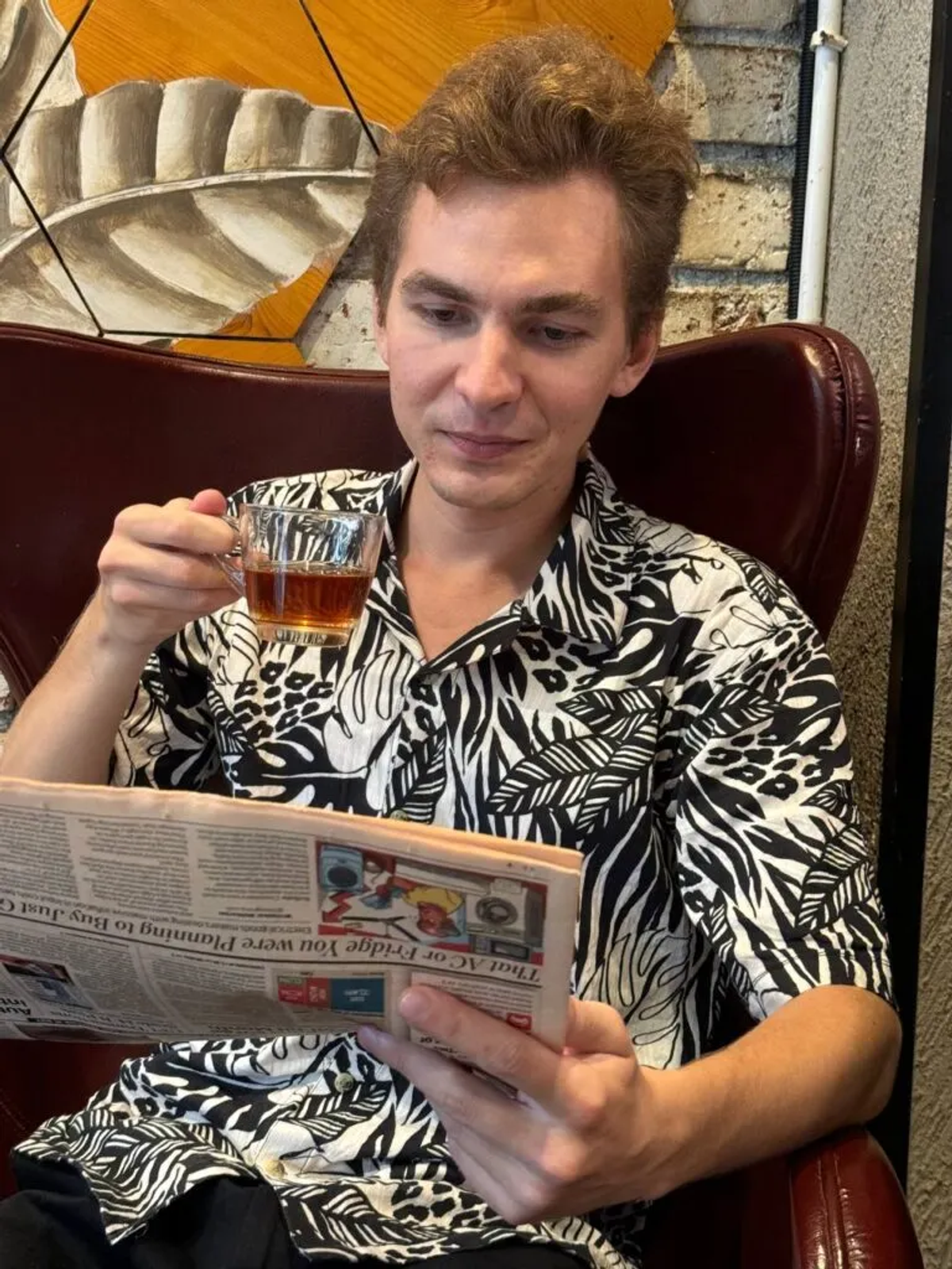Alex enjoying tea while reading newspaper