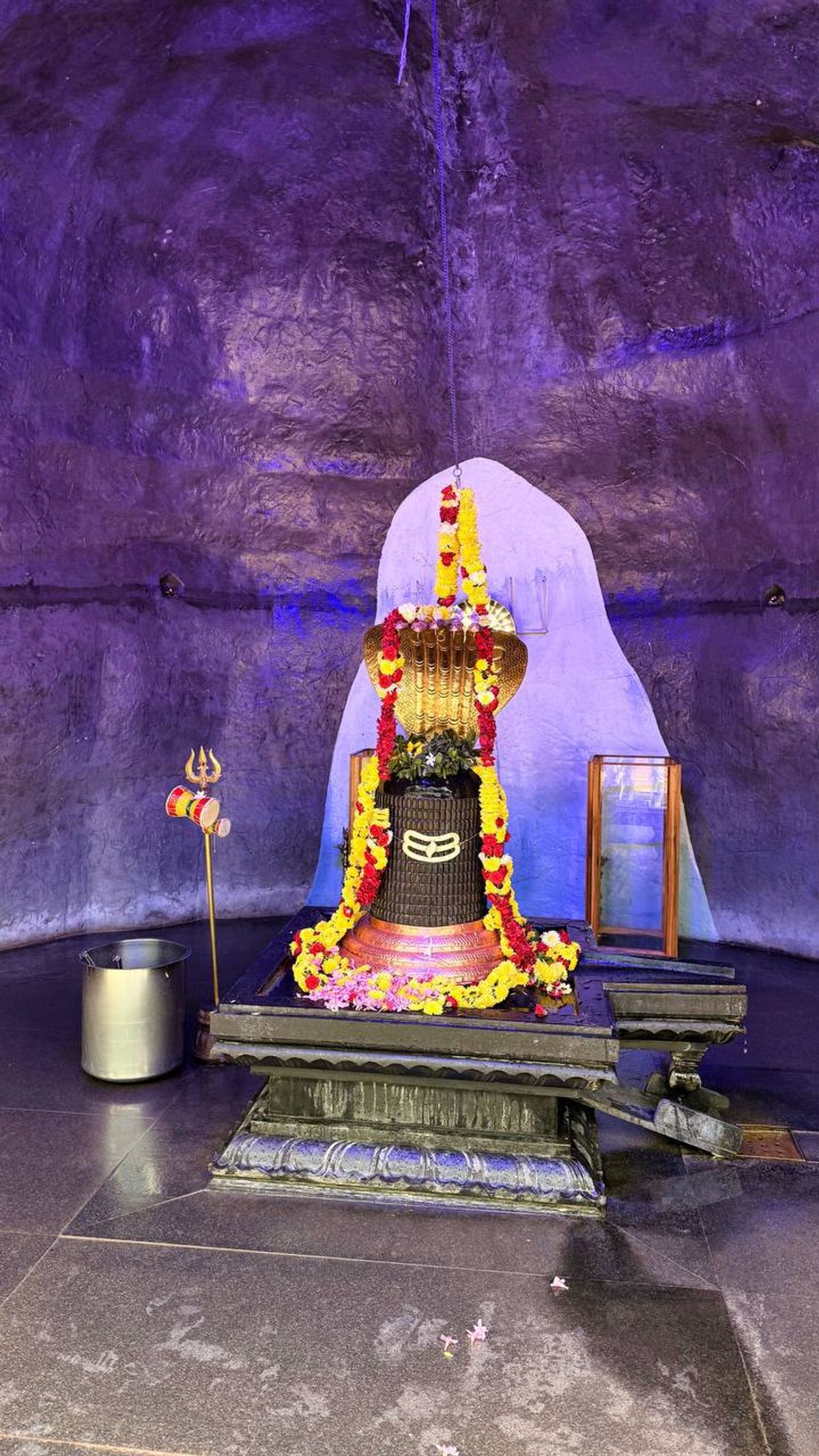 Shiva lingam with flower garlands in cave temple