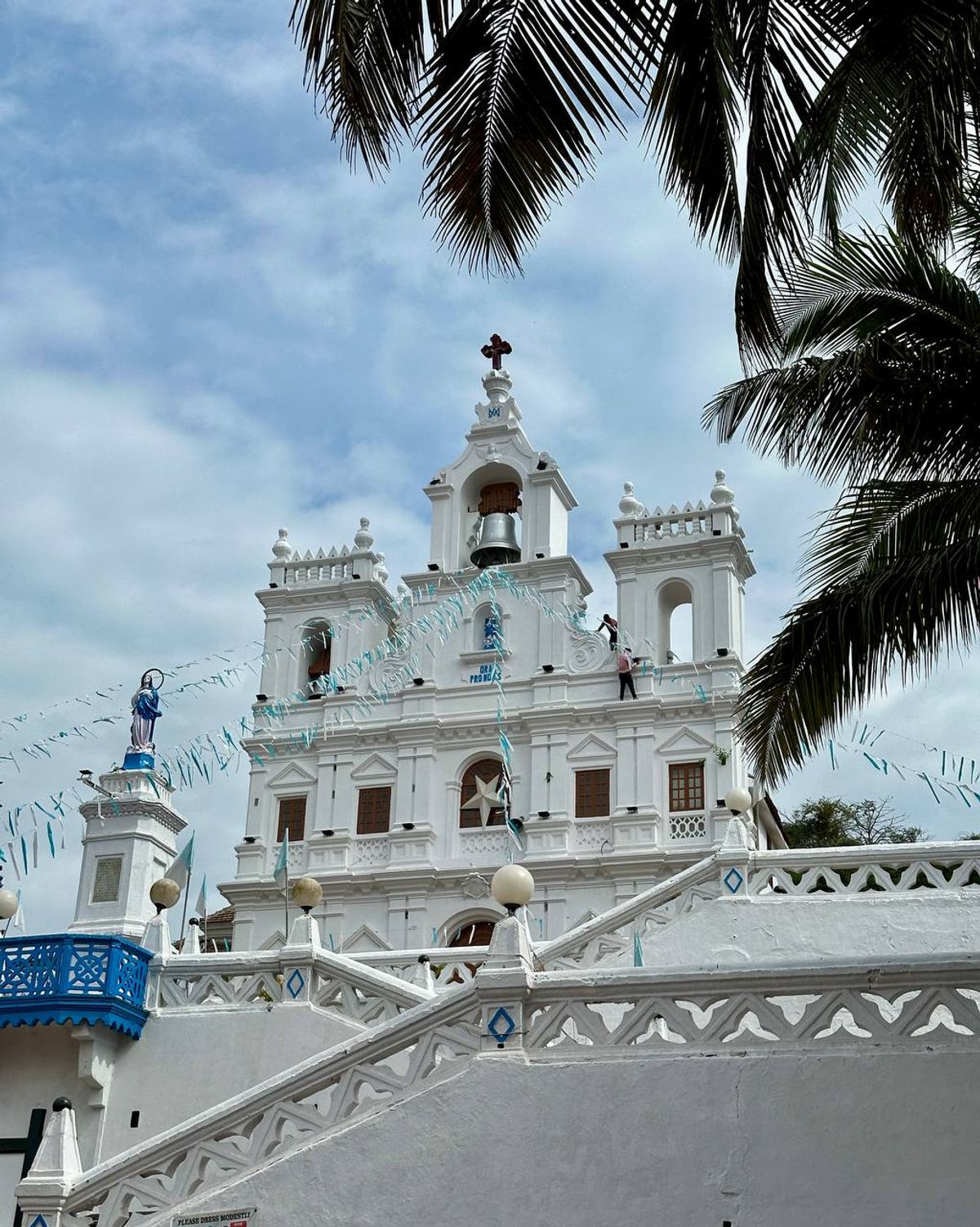 White Portuguese colonial church in Goa with palm trees