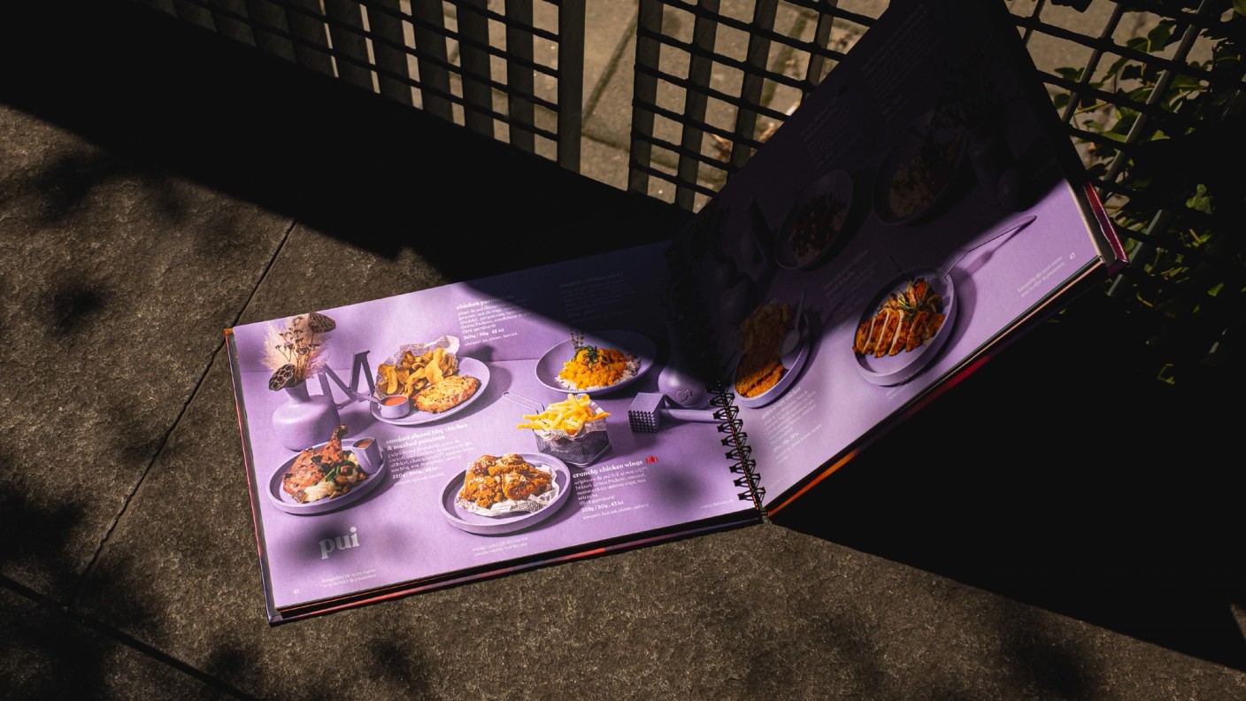Open purple Marty Restaurants menu displaying plated dishes in sunlight