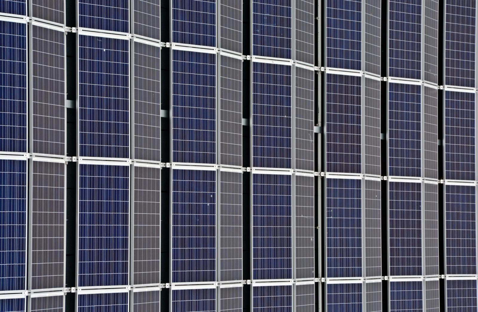 Close view of a wall of blue solar panels set in a grid.