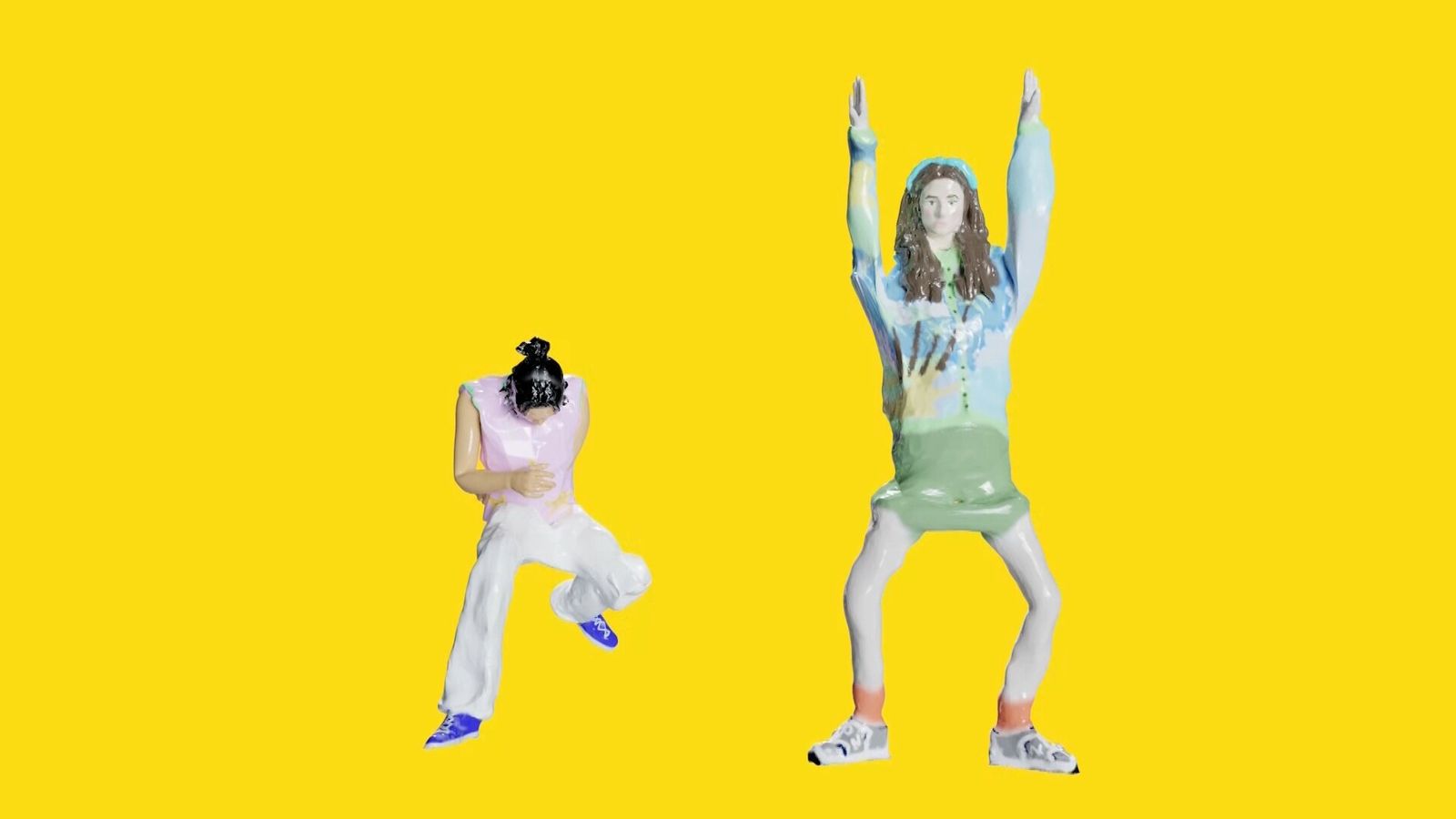 3D-scanned figures on a flat yellow background: one crouching with legs apart, the other standing with arms raised.