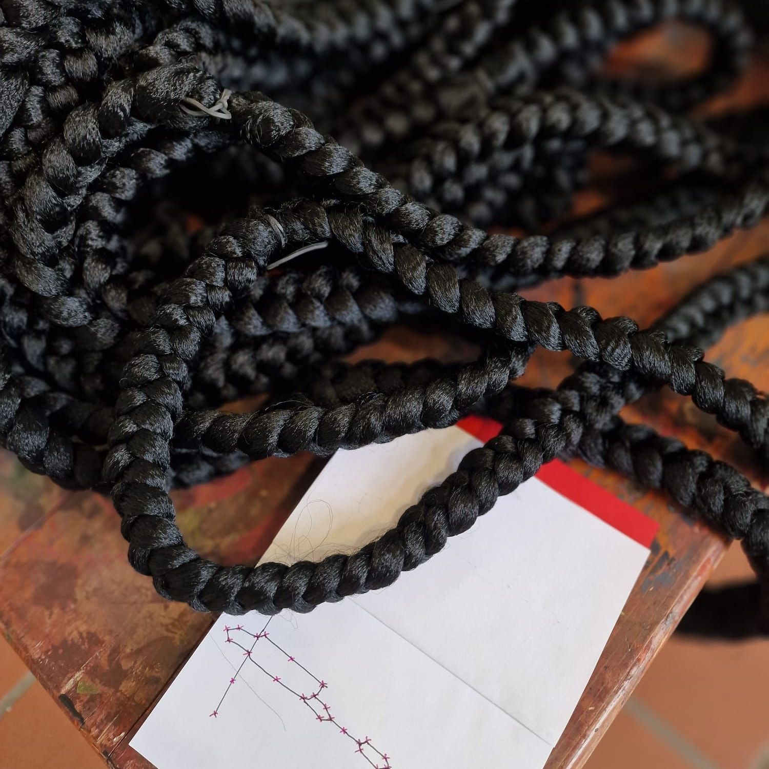 beautiful dark braids are laid on top of a diagram