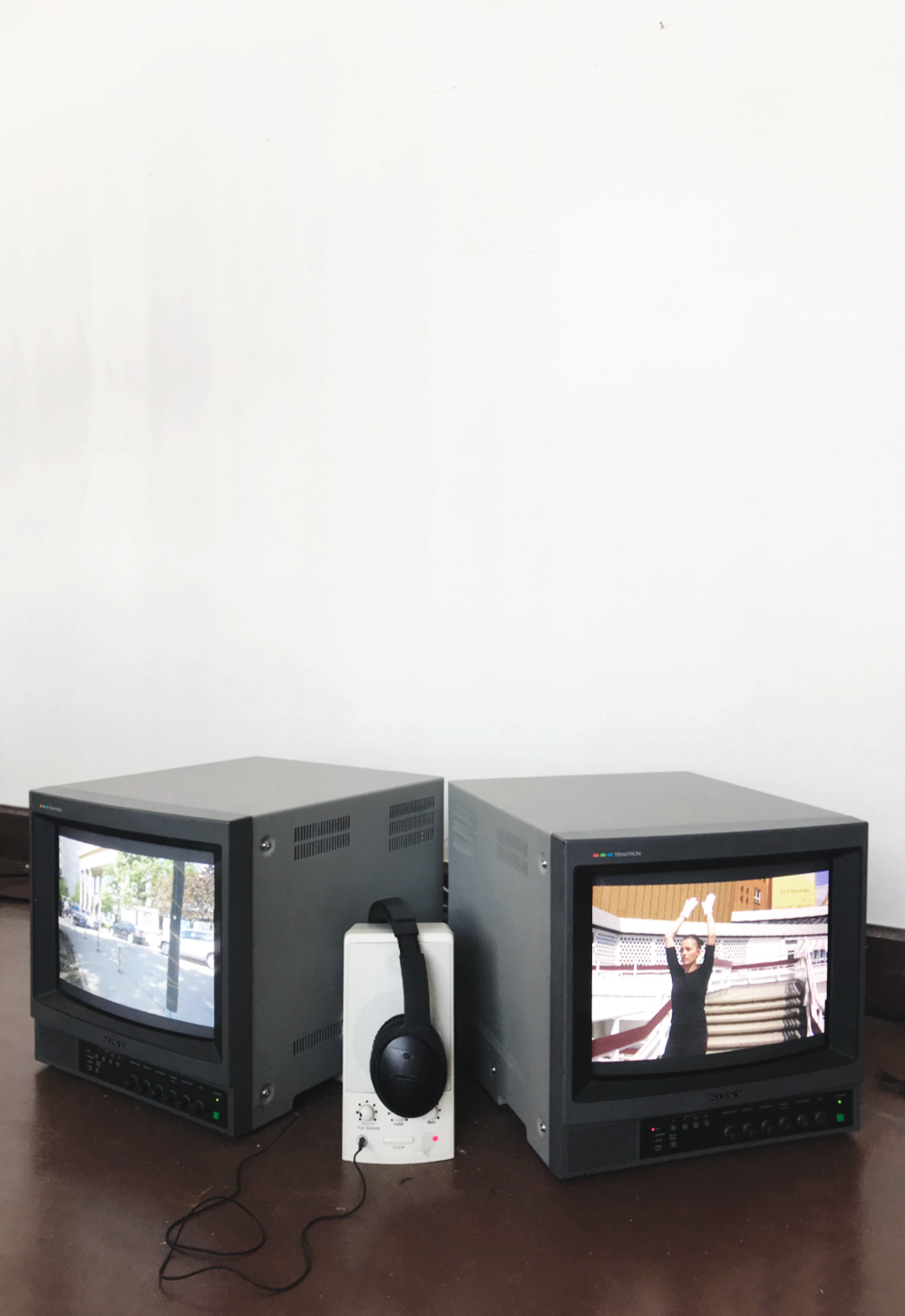Two small TV monitors with a speaker and pair of headphones between them, showing different scenes from bo lin ai yue