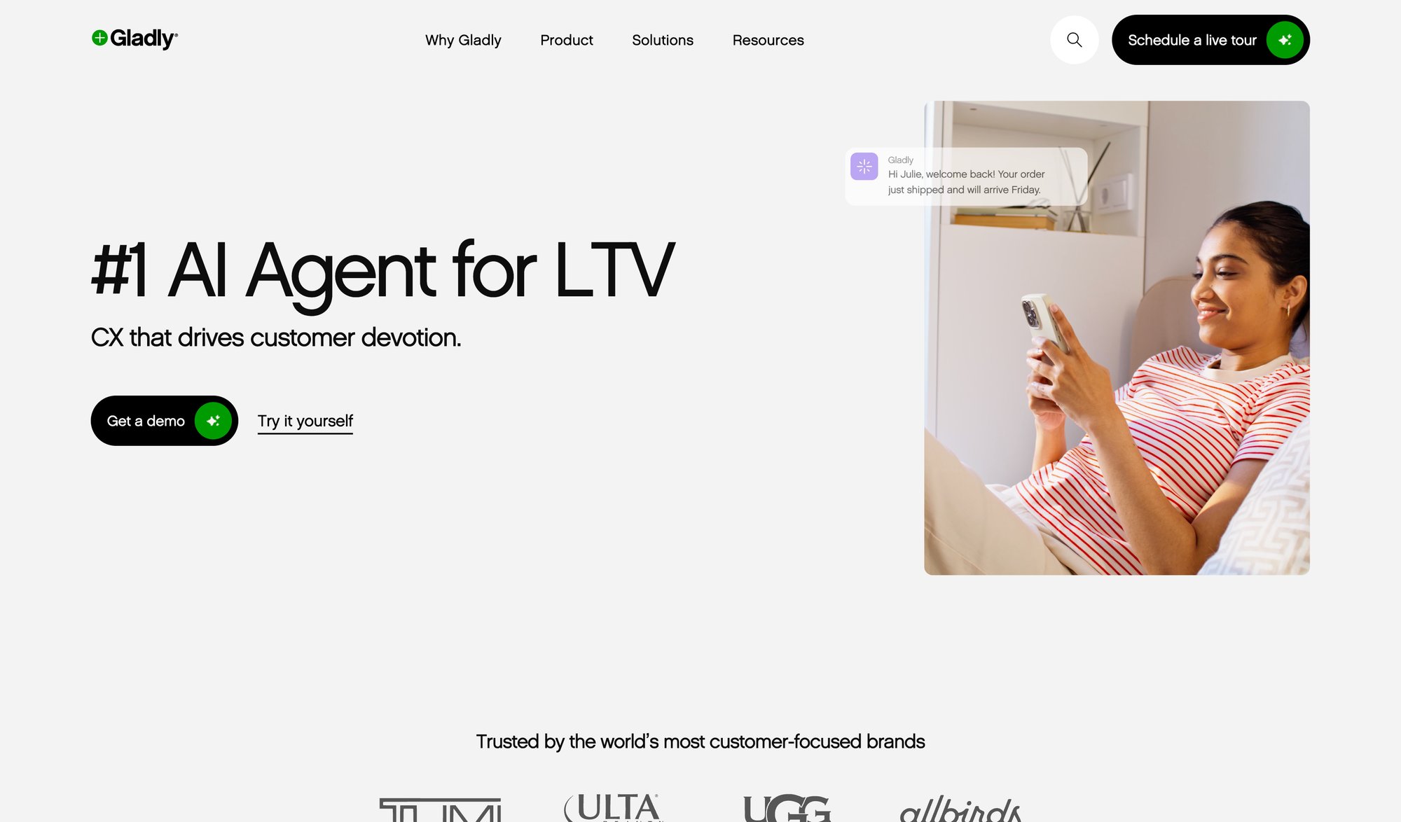 Gladly's AI agent website showing a woman smiling, looking at her phone with a customer service message.