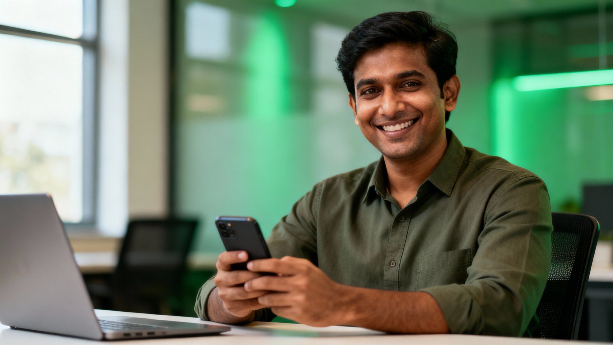 Indian business professional confidently holding smartphone in modern office, representing WhatsApp marketing success