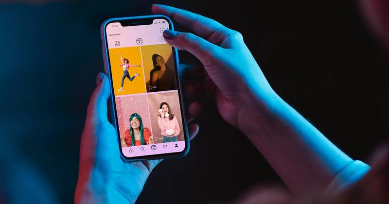 A person scrolling through influencer posts on a smartphone, illustrating the impact of influencer marketing campaigns on social media platforms.