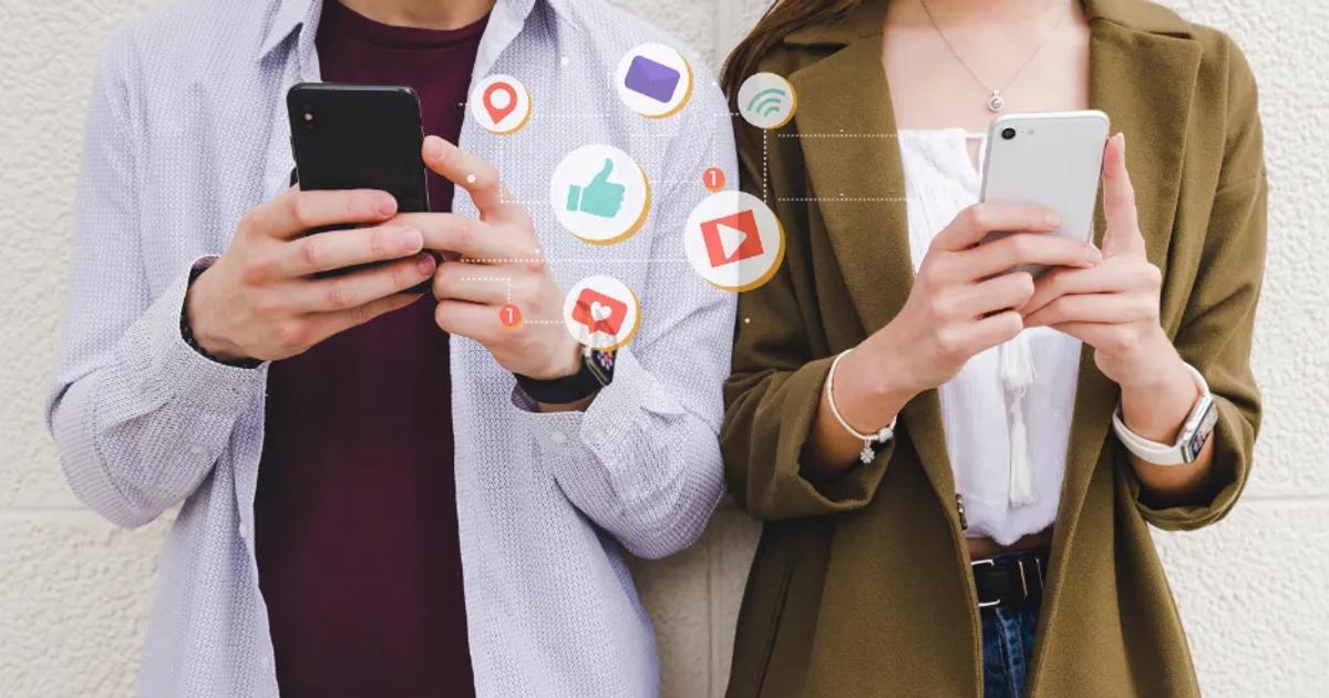Two people using smartphones with social media icons, illustrating the concept of social media marketing.