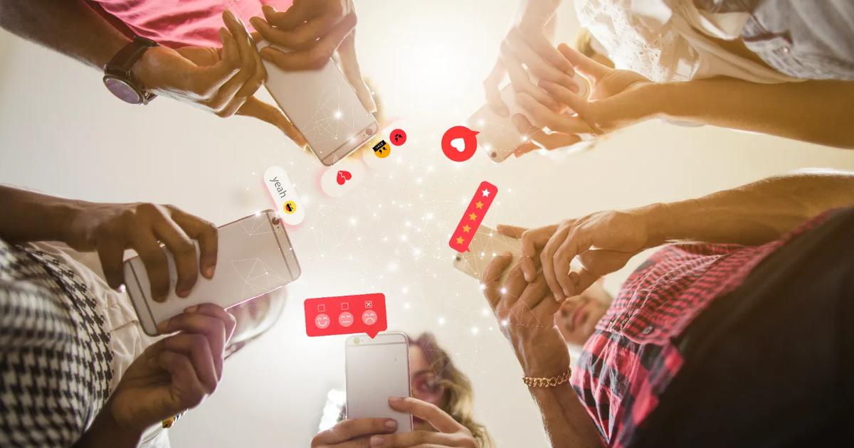 Group of people using smartphones with social icons representing interactive social media marketing campaigns.