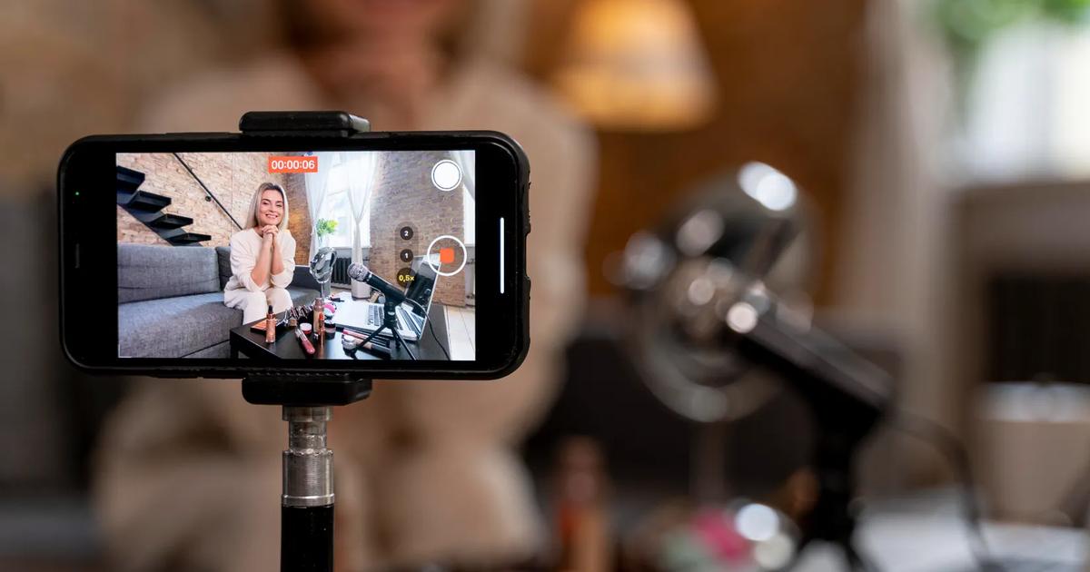 Beauty influencer recording a video with cosmetics on the table, illustrating what is a KOL in digital marketing.