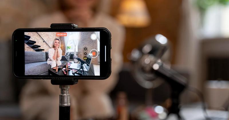 Beauty influencer recording a video with cosmetics on the table, illustrating what is a KOL in digital marketing.