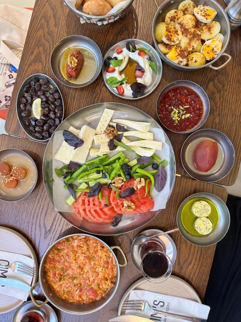 An abundant Turkish breakfast spread of cheeses, olives, eggs and fresh vegetables