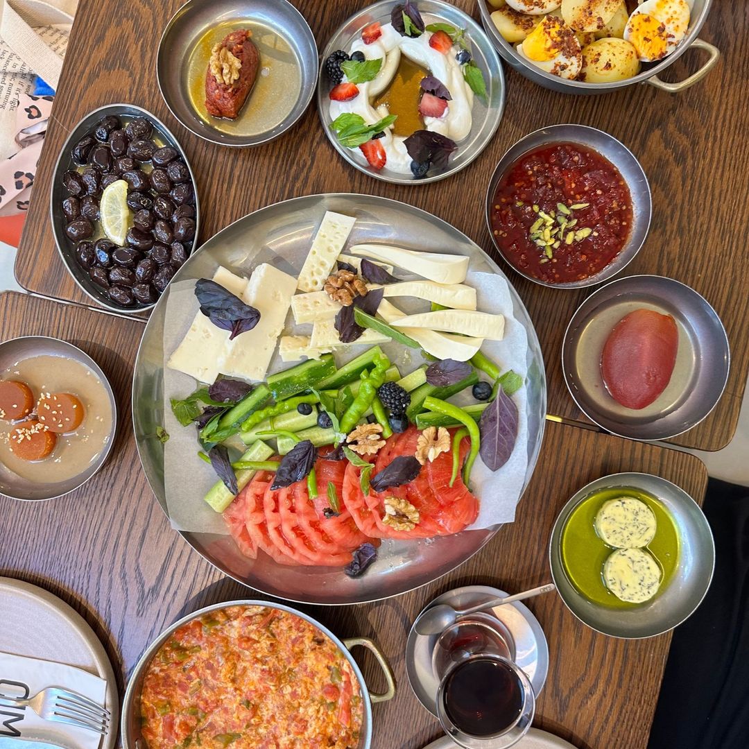 An abundant Turkish breakfast spread of cheeses, olives, eggs and fresh vegetables