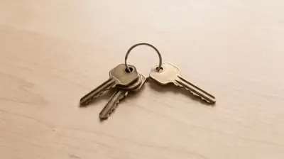 Four brass keys on a wooden table, one set slightly apart from the other three.
