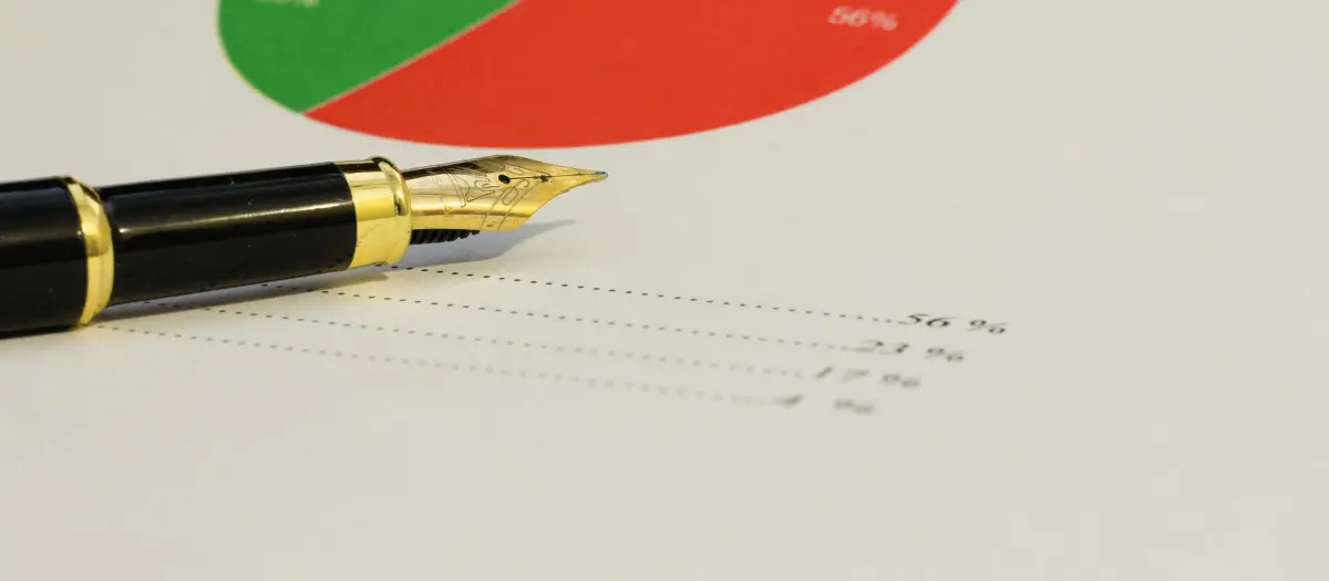 A fountain pen rests on a finanical statement