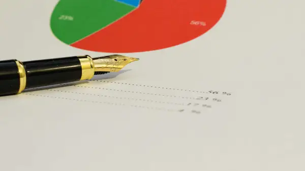 A fountain pen rests on a finanical statement