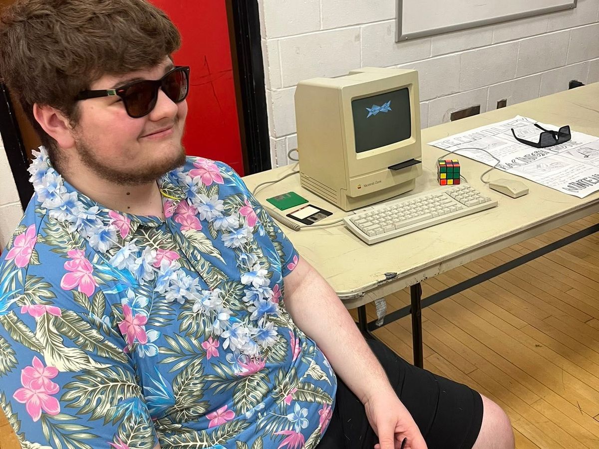 student with old apple computer