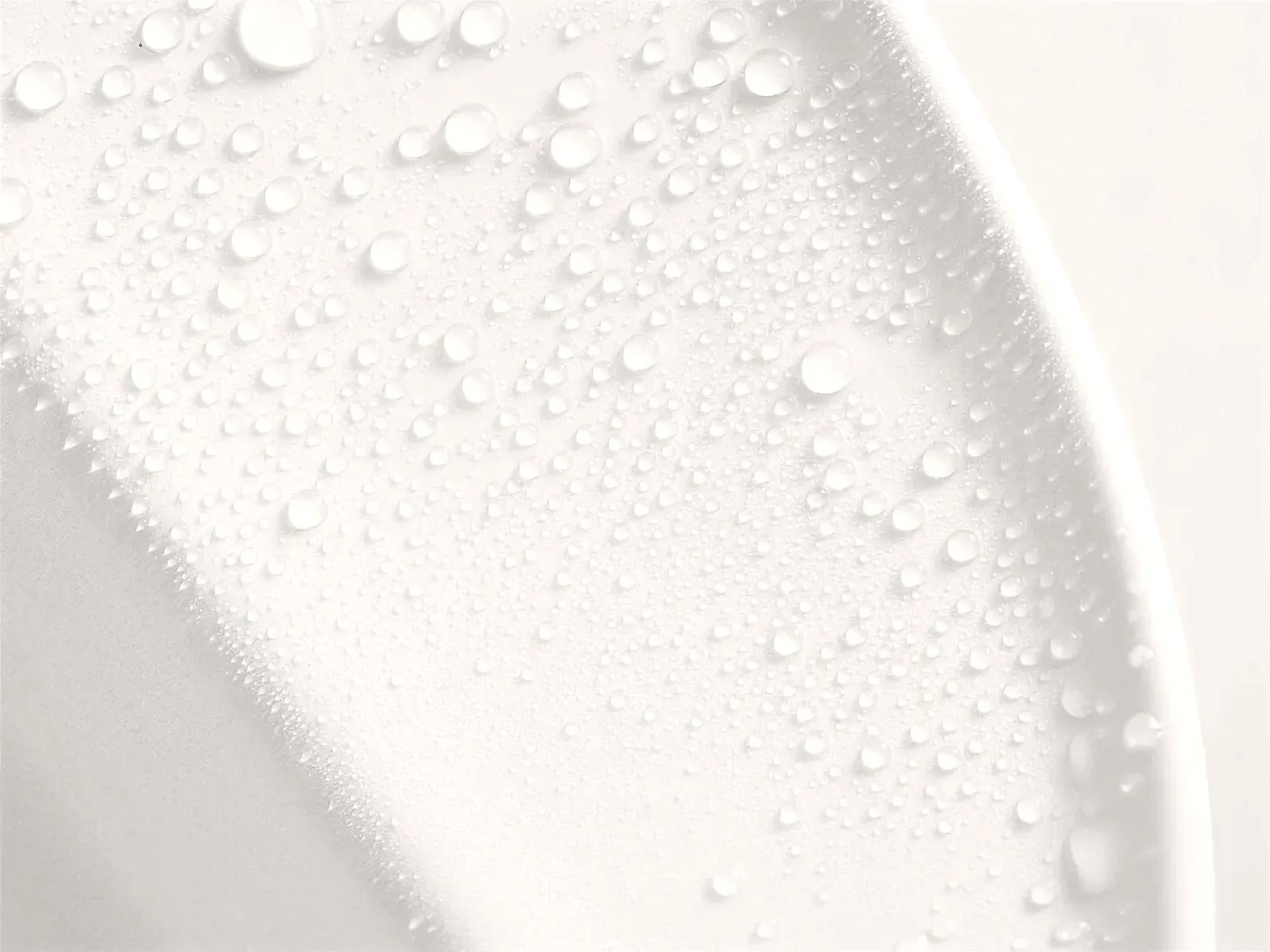 Gotas de agua sobre la superficie blanca de una bacha de porcelana, cerca del borde