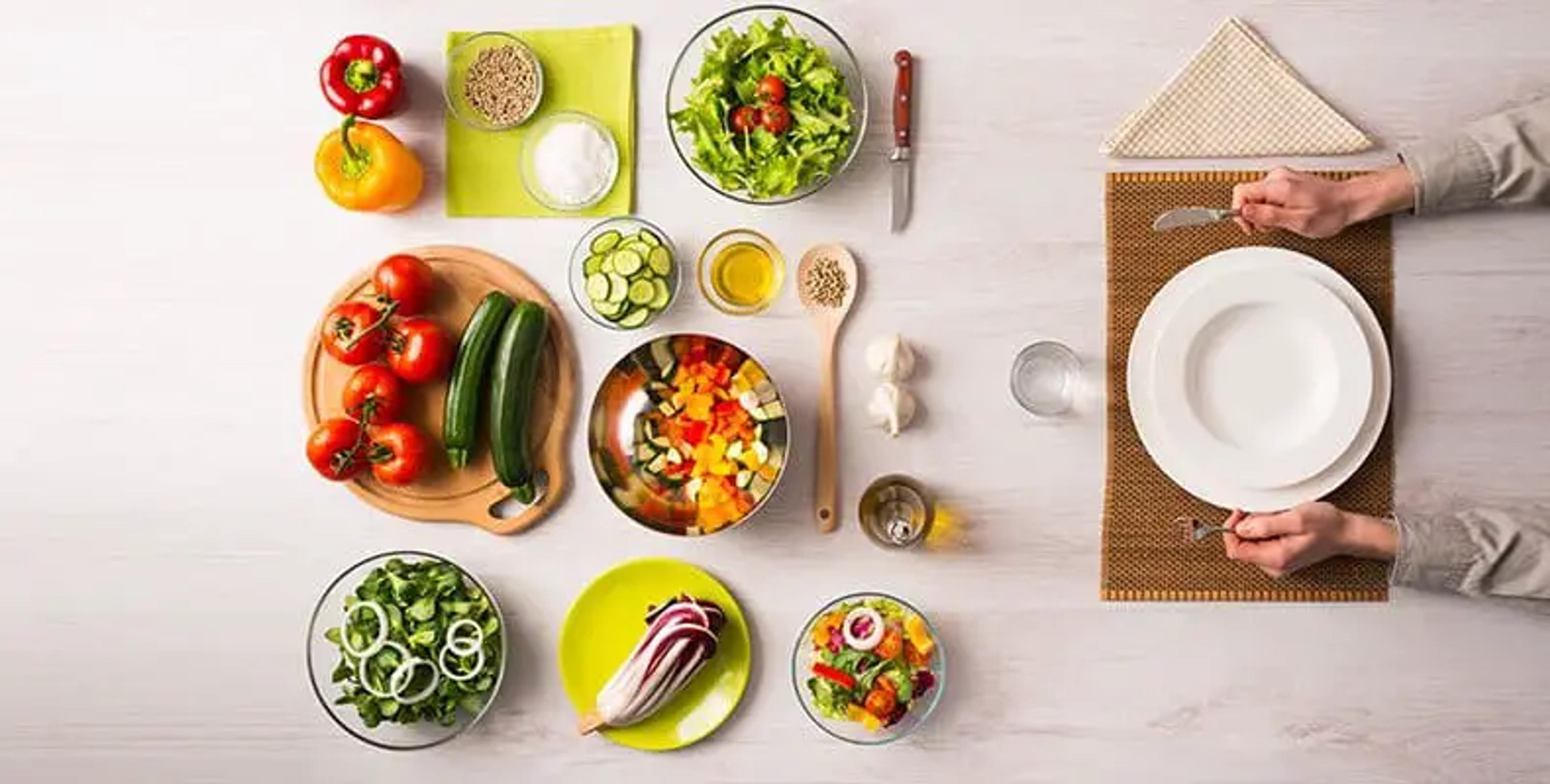 Verduras y otros ingredientes vegetales dispuestos junto a un plato.
