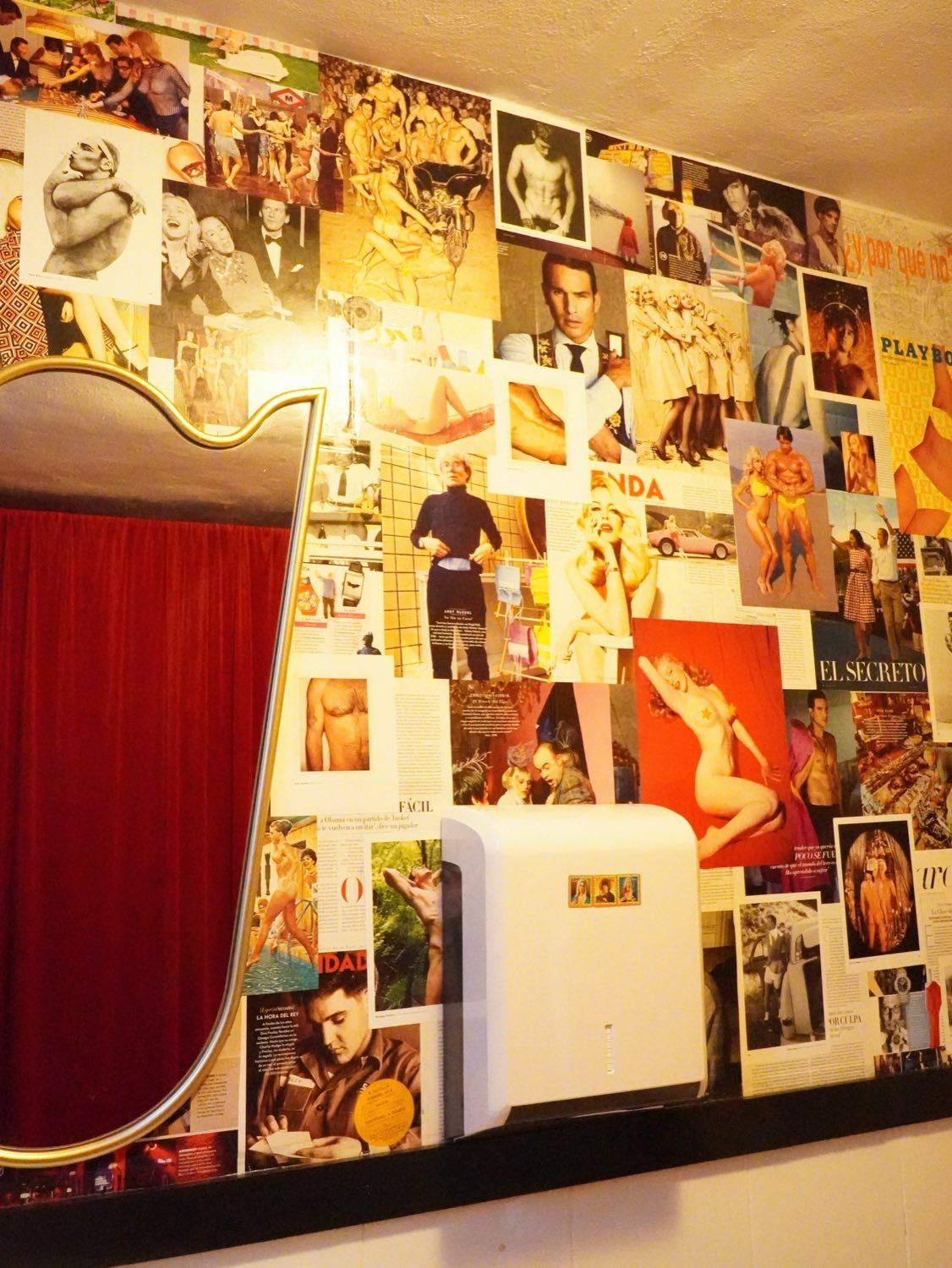 Espejo dorado junto a una pared de collage vintage