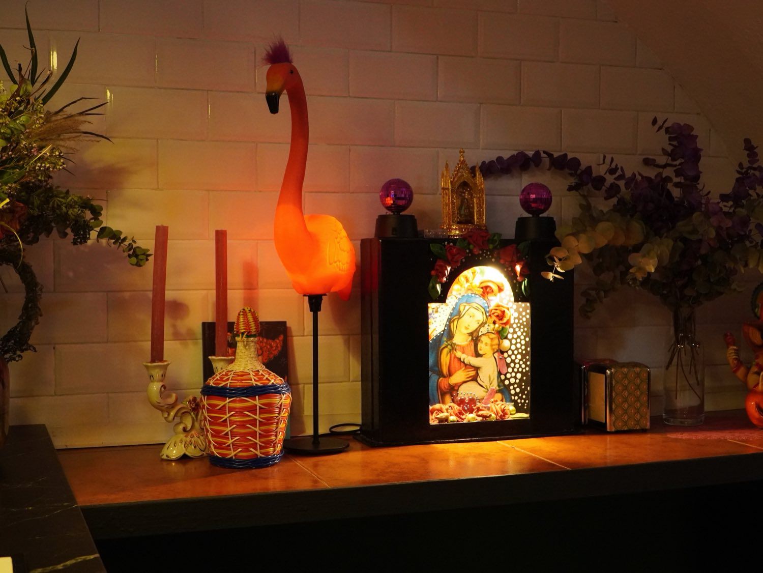 Flamenco rosa iluminado y virgen en la barra