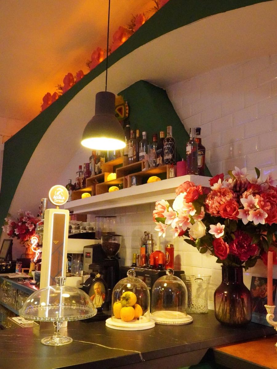 Barra con flores, campanas de cristal y botellas