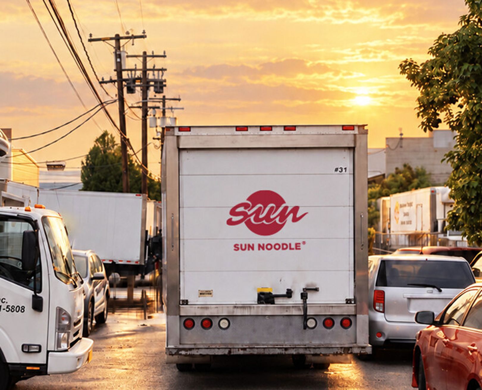 Sun Noodle delivery truck on a city street at sunset