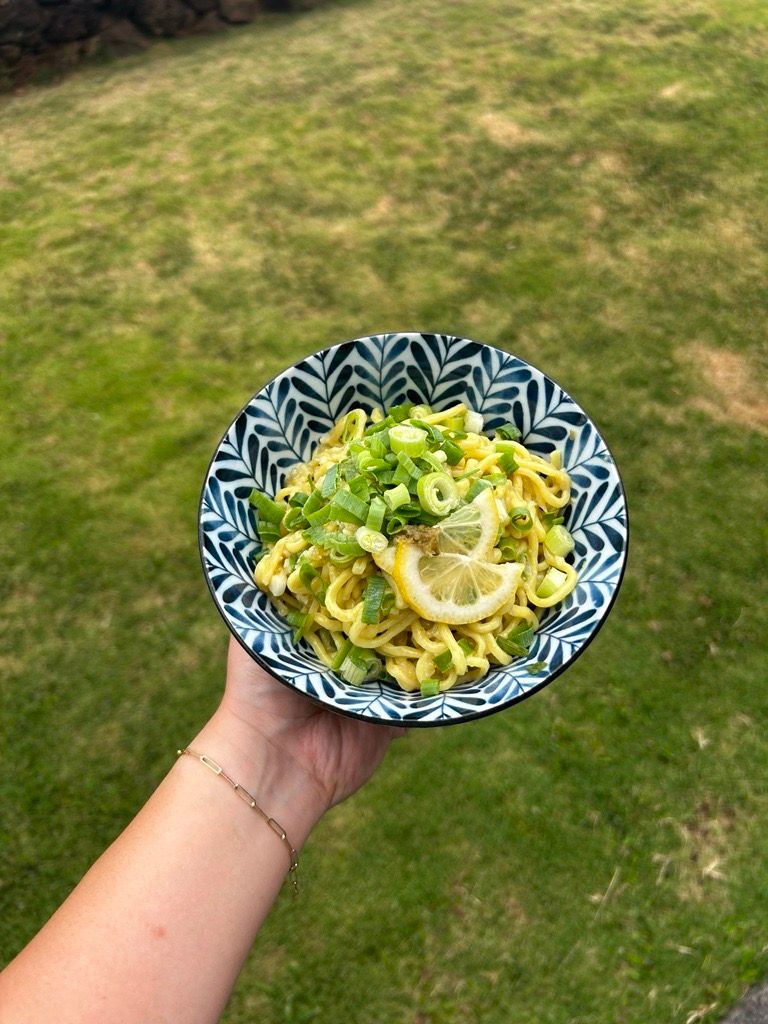 A bowl of Yuzu Kosho Mazemen topped with sliced lemon, green onions, and yuzu kosho