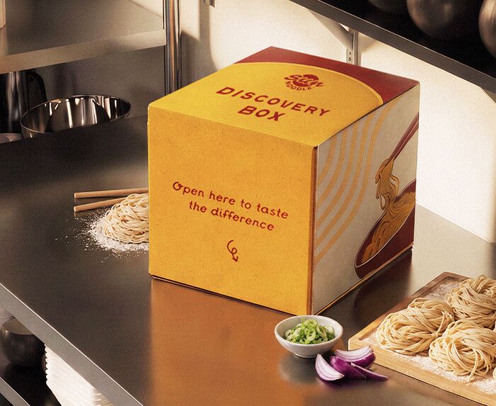 Sun Noodle Discovery Box on a kitchen counter next to fresh noodles