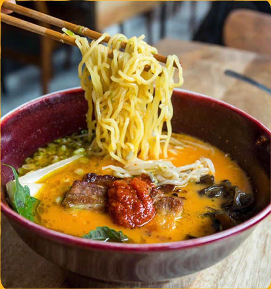 Noodles lifted from a bowl of spicy ramen