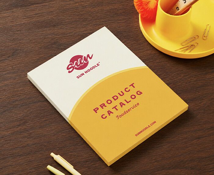 Sun Noodle foodservice product catalog on a wooden desk