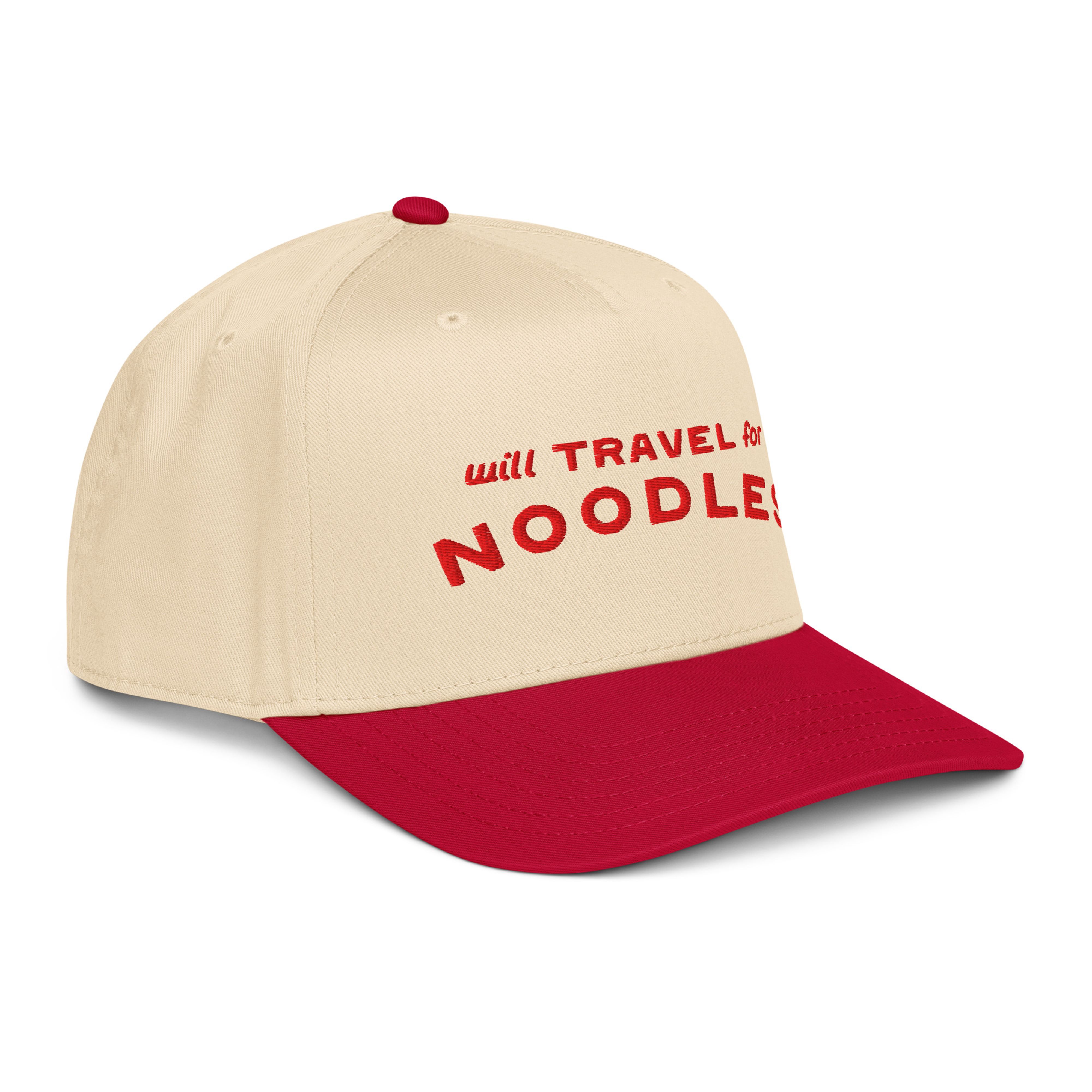 Three-quarter front view of the cream and red "will TRAVEL for NOODLES" cap from the opposite side, showing the red brim and crown.