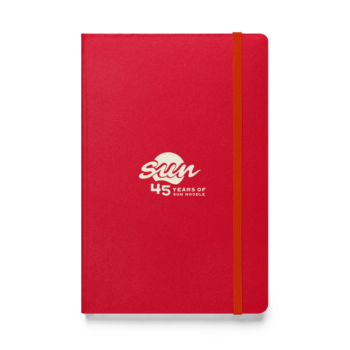 Red hardcover bound notebook with an orange elastic closure band, featuring the cream "45 Years of Sun Noodle" logo centered on the cover, with a stylized "sun" script over a circle.