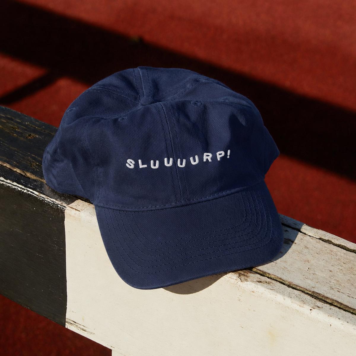 Navy blue hat with "SLUUUURP!" embroidered in white across the front in spaced-out lettering.