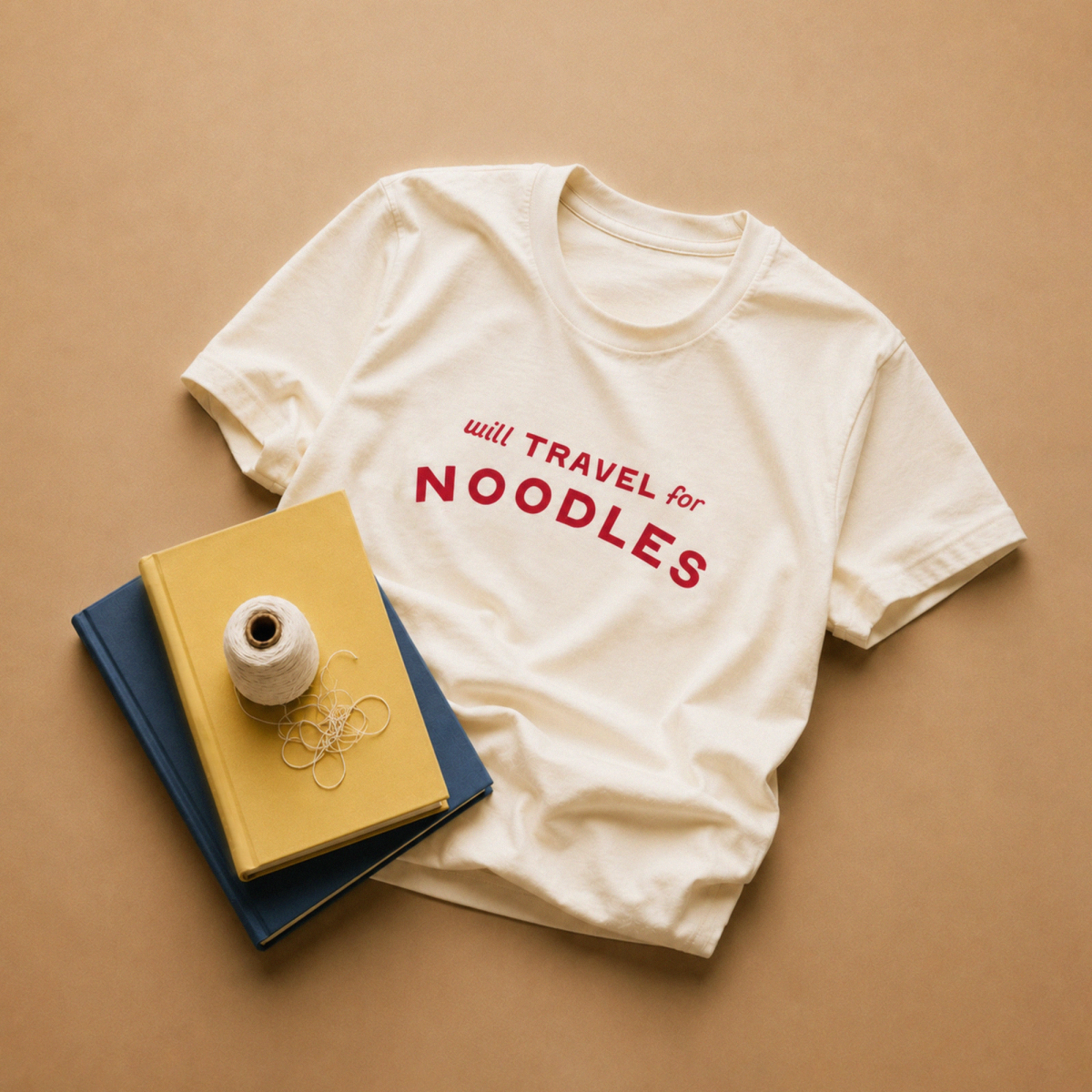 Natural cream unisex t-shirt with "will TRAVEL for NOODLES" printed across the chest in red lettering.