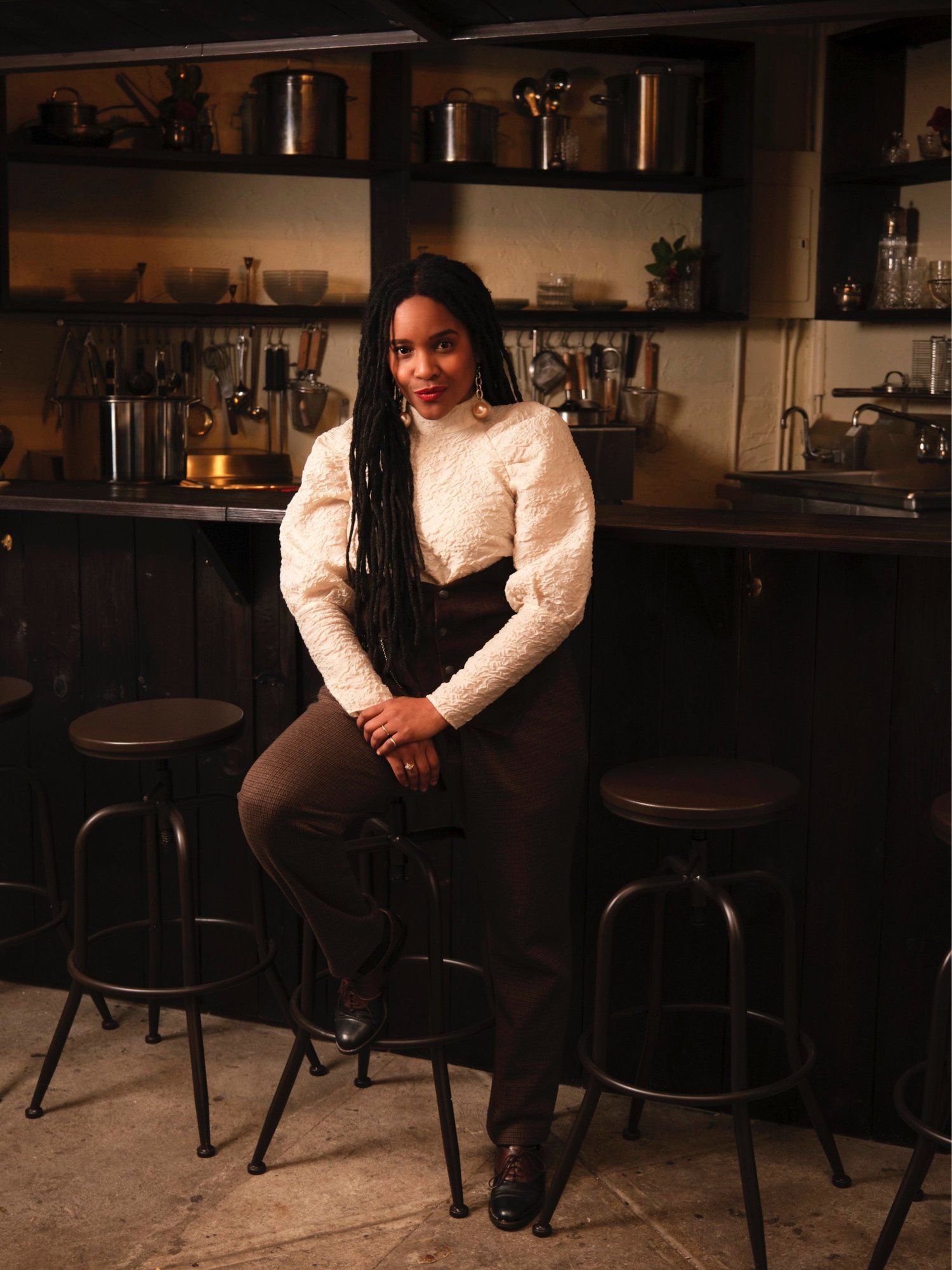 Rasheeda sitting on a stool at Ramen by Ra