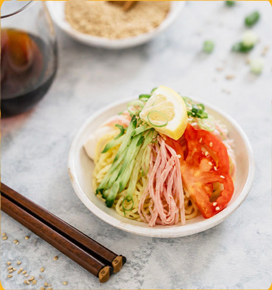Chilled noodle salad with ham, cucumber, egg and tomato