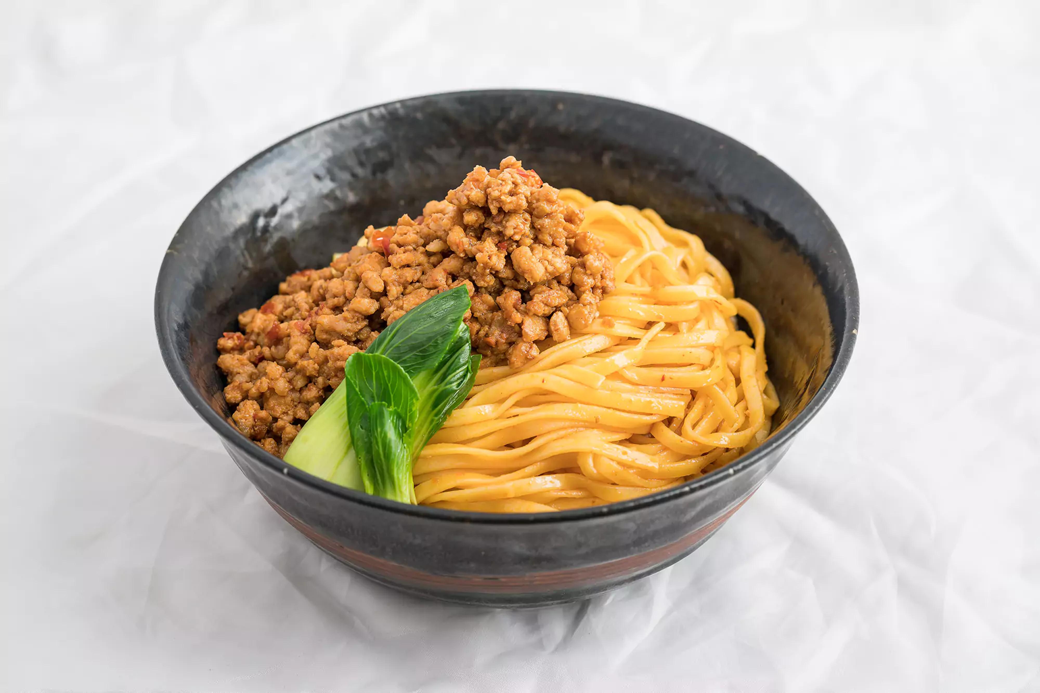 Spicy sesame mazemen on a bowl with protein and bok choi.