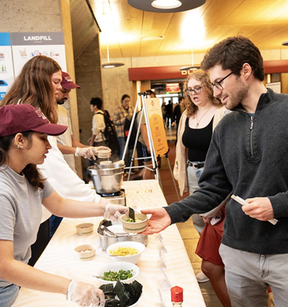 Students being served ramen at a campus dining event
