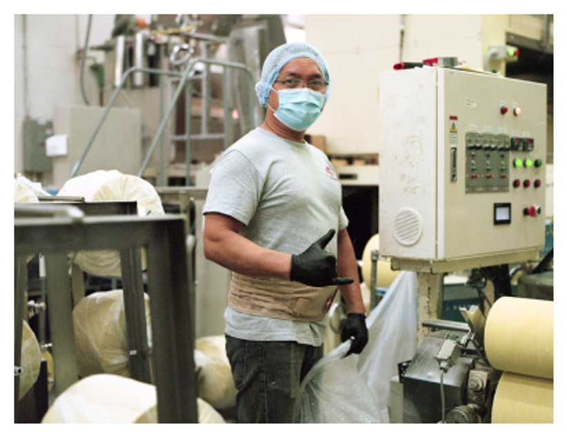 An employee with a face mask makes a shaka sign for the camera