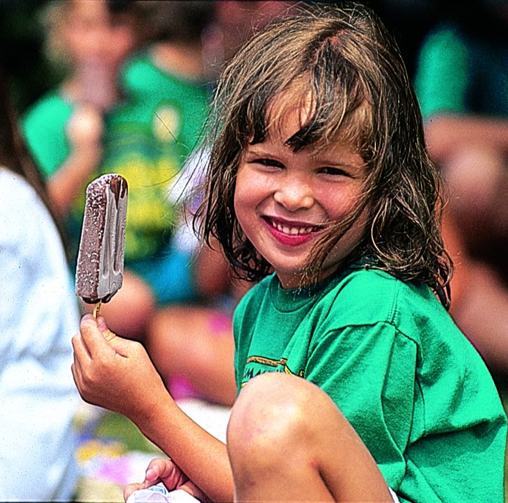 Rambling Pines Camper smiling and holding an icecream.