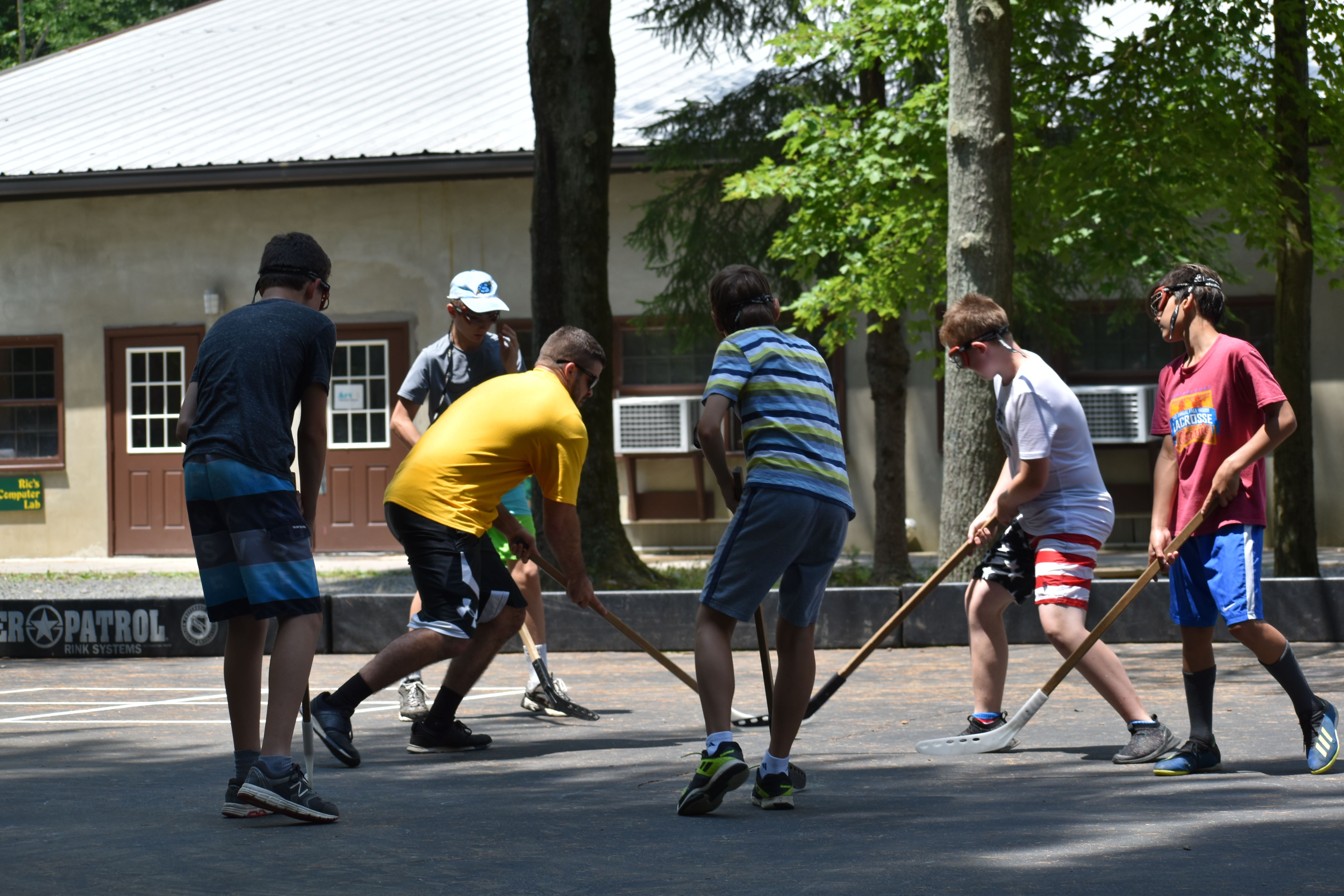 teens playing street hockey at Rambling Pines Day Camp
