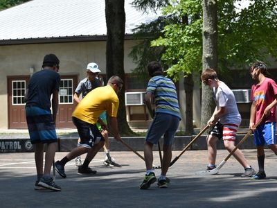teens playing street hockey at Rambling Pines Day Camp